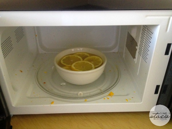 Bowl with vinegar and lemons in a microwave