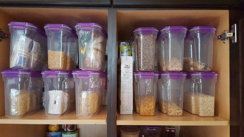 Containers filled with dry goods organized on a cabinet shelf